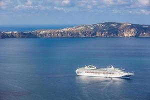 beau paysage avec vue sur la mer. bateau de croisière dans la baie bleue près de la ville de fira. merveilleux paysage de voyage. fond de transport de voyage et de tourisme à santorin grèce photo