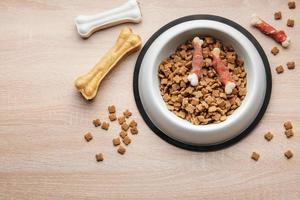 un bol de nourriture pour chien sur un plancher en bois. photo