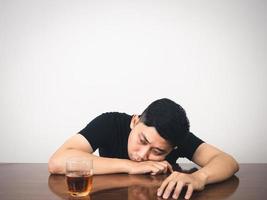 homme ivre assis à table avec un verre d'alcool se sent déprimé photo