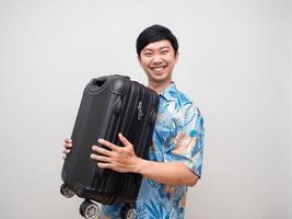 jeune homme chemise de plage porter des bagages heureux de vacances isolées photo
