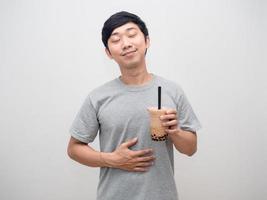 positivel man holding boba tea bonheur sourire tapoter son ventre se sent plein photo