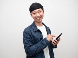 Cheerful man doux sourire jeans shirt geste à l'aide de portrait de téléphone mobile photo