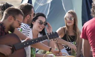 été, vacances, vacances, musique, concept de gens heureux - groupe d'amis avec guitare s'amusant sur la plage photo