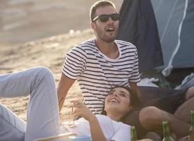 concept de vacances de pique-nique. beau couple s'amusant à faire un barbecue sur un feu de joie et à se détendre au bord d'un lac. photo