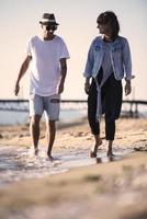 heureux couple romantique profitant d'une belle promenade au coucher du soleil sur la plage. concept de mode de vie de retraite de vacances de voyage photo