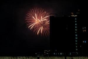 feux d'artifice sur la rivière dans le ciel sombre, bonne année 2023, thaïlande. photo