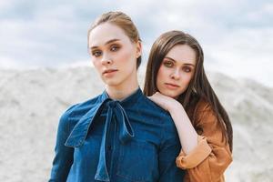 portrait de beauté de mode de jeunes femmes soeurs en chemises de jeans de velours bio marron sur fond de désert photo