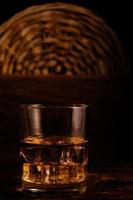 whisky réfrigéré en verre avec des glaçons sur fond de bois dans la cave. photo