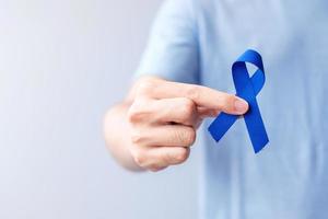 mars mois de sensibilisation au cancer colorectal, femme tenant un ruban bleu foncé pour soutenir les personnes vivant et malades. soins de santé, espoir et concept de la journée mondiale du cancer photo