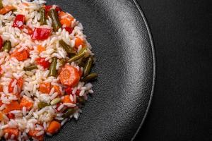 délicieux risotto frais aux légumes, épices et herbes sur une plaque noire photo