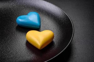 coeurs en chocolat aux couleurs du drapeau ukrainien sur une plaque en céramique noire photo