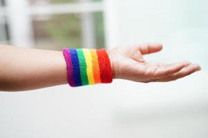 femme asiatique avec drapeau arc-en-ciel, droits des symboles lgbt et égalité des sexes, mois de la fierté lgbt en juin. photo