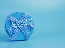 Boîte cadeau bleu pour bébé garçon isolé sur fond bleu photo