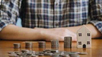 homme d'affaires détenant des pièces de monnaie mettant dans du verre avec une calculatrice pour calculer le concept d'économie d'argent pour la comptabilité financière, les affaires, la finance, l'investissement, la planification financière. photo