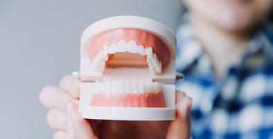 concept de stomatologie, portrait partiel d'une fille avec de fortes dents blanches regardant la caméra et souriant, les doigts près du visage. gros plan sur une jeune femme chez le dentiste, en studio, à l'intérieur photo