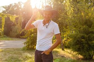 un homme portant un chapeau de cow-boy, un jean et une ceinture. photo