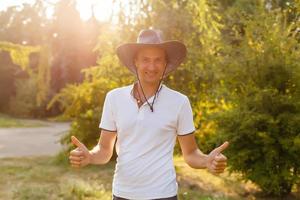 un homme portant un chapeau de cow-boy, un jean et une ceinture. photo