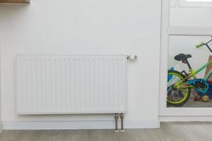 radiateur de chauffage blanc au mur dans un appartement avec parquet photo