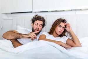 notion de relation. vue de dessus du jeune couple allongé sur le lit. couple se disputant dans le lit. concept de relation et de problèmes entre couples. déception sexuelle. les amoureux s'ignorent photo