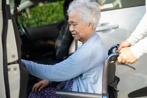 Une patiente asiatique âgée ou âgée, assise sur un fauteuil roulant, se prépare à aller à sa voiture, concept médical solide et sain. photo