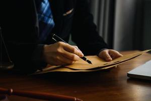 affaires et avocats discutant des documents contractuels avec une échelle en laiton sur le bureau au bureau. droit, services juridiques, conseils, image de concept de justice et de droit avec effet de grain de film photo