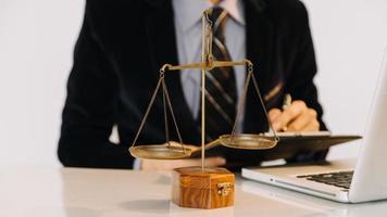 affaires et avocats discutant des documents contractuels avec une échelle en laiton sur le bureau au bureau. droit, services juridiques, conseil, concept de justice et de droit photo