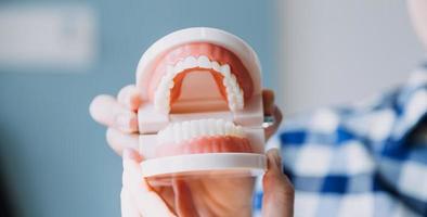 concept de stomatologie, portrait partiel d'une fille avec de fortes dents blanches regardant la caméra et souriant, les doigts près du visage. gros plan sur une jeune femme chez le dentiste, en studio, à l'intérieur photo