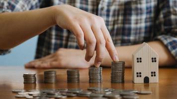 homme d'affaires détenant des pièces de monnaie mettant dans du verre avec une calculatrice pour calculer le concept d'économie d'argent pour la comptabilité financière, les affaires, la finance, l'investissement, la planification financière. photo