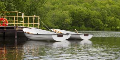 bateaux à rames près de la jetée sur le lac photo