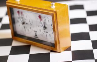 Horloge d'échecs mécanique classique sur un échiquier en bois photo