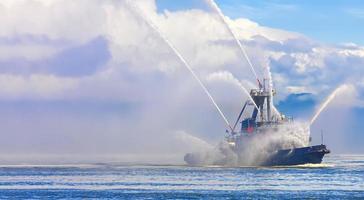 le remorqueur flottant pulvérise des jets d'eau photo