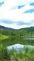 le lac ilent près de la forêt verte et du ciel nuageux photo