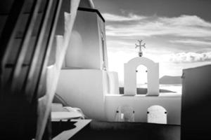 santorin village de fira surplombant la mer, grèce. processus noir et blanc de l'église et de l'architecture blanche photo