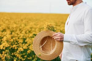 homme posant sur un champ de fleurs jaunes photo