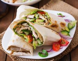 tortillas fraîches avec poulet et légumes frais sur assiette. photo