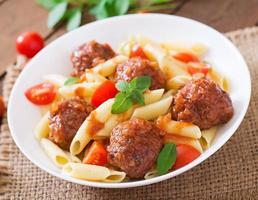 pâtes penne aux boulettes de viande à la sauce tomate dans un bol blanc photo