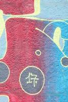 fragment de dessins de graffitis. le vieux mur décoré de taches de peinture dans le style de la culture de l'art de la rue. texture de fond multicolore photo