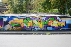 fragment de dessins de graffitis. le vieux mur décoré de taches de peinture dans le style de la culture de l'art de la rue. texture de fond multicolore photo
