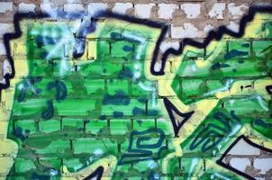 fragment d'un vieux dessin de graffiti coloré sur le mur. image d'arrière-plan illustrant l'art de la rue, le vandalisme et la peinture murale avec de la peinture aérosol photo