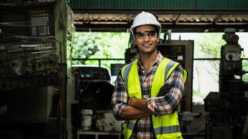 Portrait bel ingénieur dans une usine, travailleur souriant du Moyen-Orient portant un chapeau blanc avec un gilet de sécurité vert dans l'industrie photo