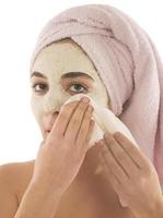 procédures de beauté concept de soins de la peau. jeune femme appliquant un masque d'argile de boue faciale sur son visage photo