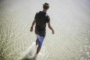 homme marchant sur une eau cristalline. concept d'été du lac photo