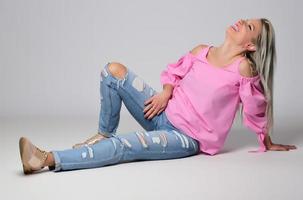 femme souriante à la mode blonde portant des accessoires modernes posant en studio photo