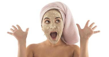 procédures de beauté concept de soins de la peau. jeune femme appliquant un masque d'argile de boue faciale sur son visage photo