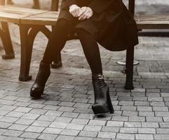 femme en manteau noir et bottes en cuir photo