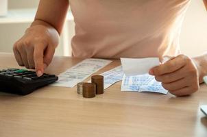 les femmes utilisent une calculatrice pour calculer les dépenses avec des factures placées sur la table. notion de dette photo