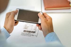 l'homme d'affaires utilise le téléphone pour scanner le code-barres ou les codes qr pour payer la facture de carte de crédit après avoir reçu la facture du document en ligne. paye moi photo