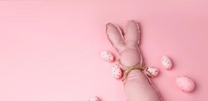 bannière de pâques rose monochrome avec lapins jouets et oeufs. place pour le texte photo