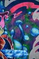 un fragment de graffiti détaillé d'un dessin réalisé avec des peintures en aérosol sur un mur de carreaux de béton. image de fond d'art de rue avec des champignons bleus féeriques photo
