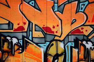 un fragment de graffiti détaillé d'un dessin réalisé avec des peintures en aérosol sur un mur de carreaux de béton. image de fond d'art de rue dans des tons chauds de couleur rouge photo